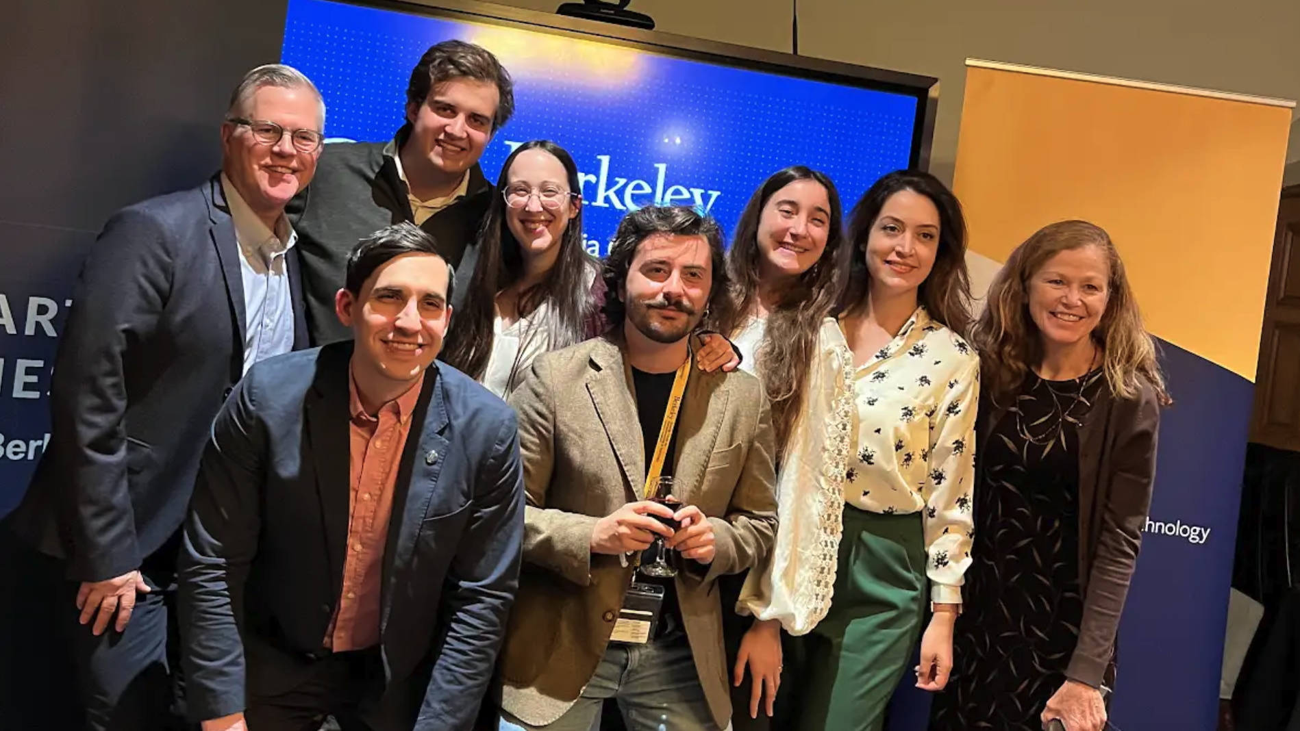 Giulio Pantano stands alongside several peers as they pose for a group photo in front of a Berkeley Sutardja Center for Entrepreneurship and Technology banner in an indoor auditorium environment